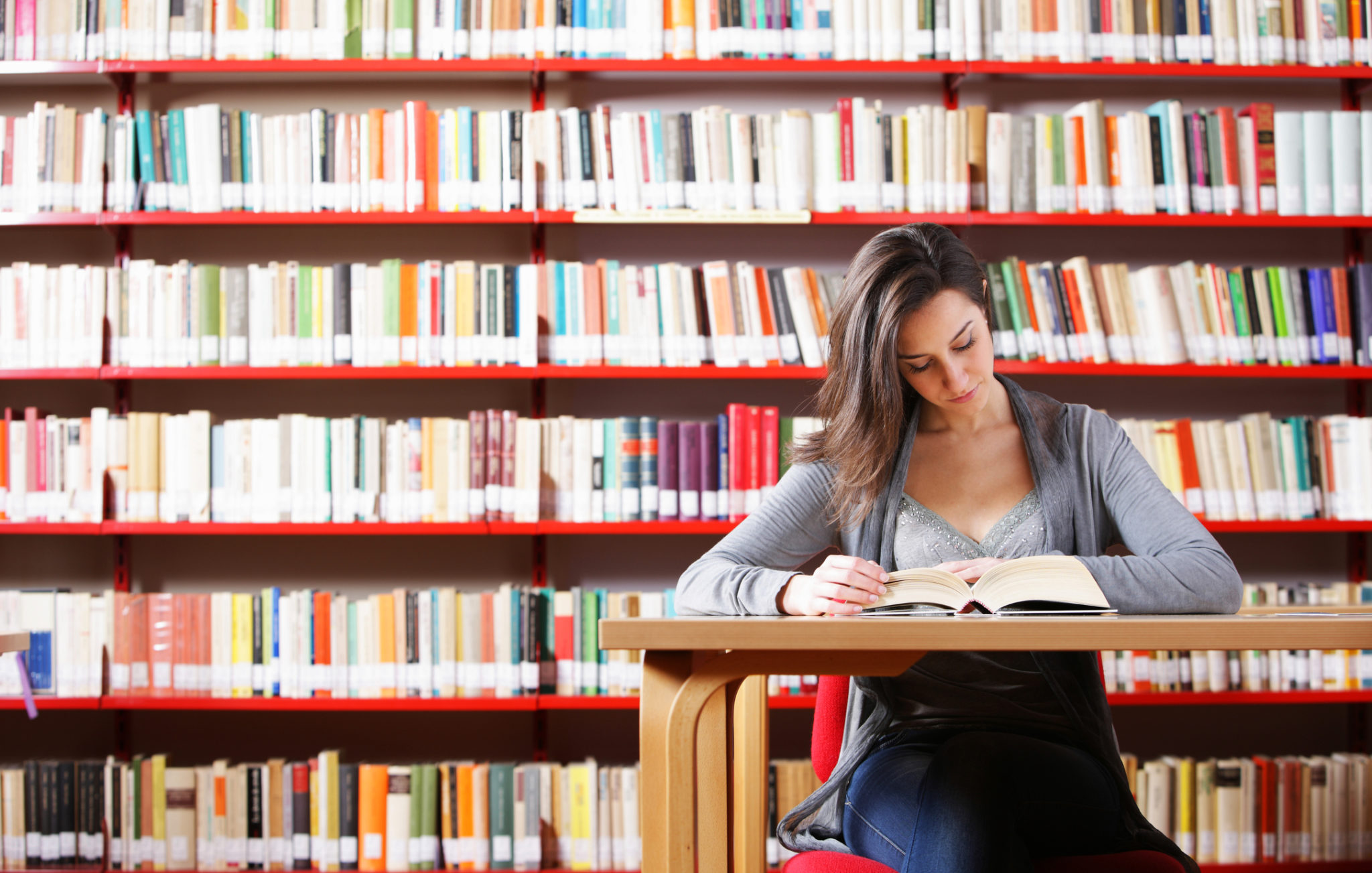 Студентка в очах читает в библиотеке обнаженной фото