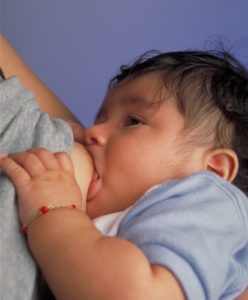 A baby nurses at its mother's breast.