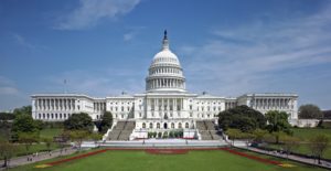 The exterior of the US Capitol Building on a sunny day.